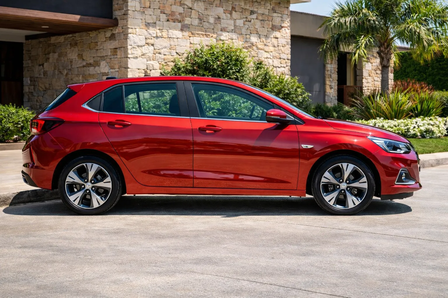 Chevrolet Onix vermelho em frente a casa